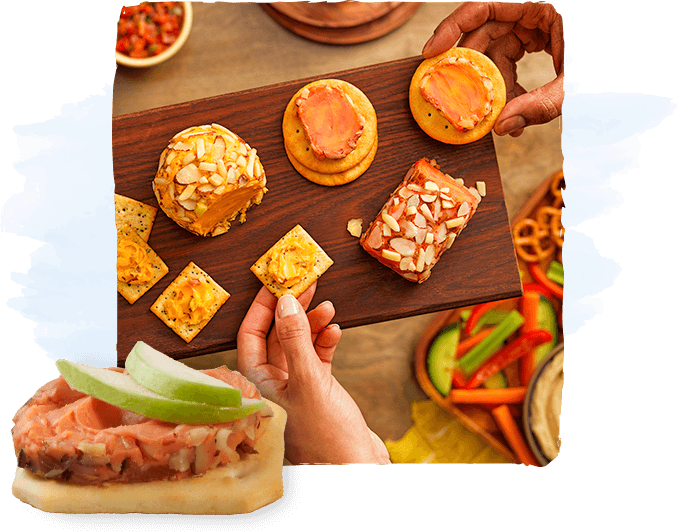 Assorted bite-sized canapés on a wooden board, held by hands, with a salmon-topped sandwich in the foreground.